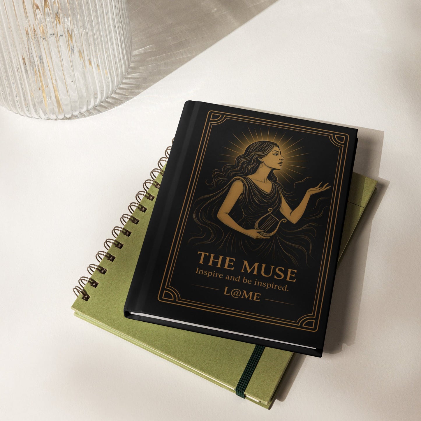 Matte black hardcover journal with gold Muse tarot-style artwork and lined pages.
