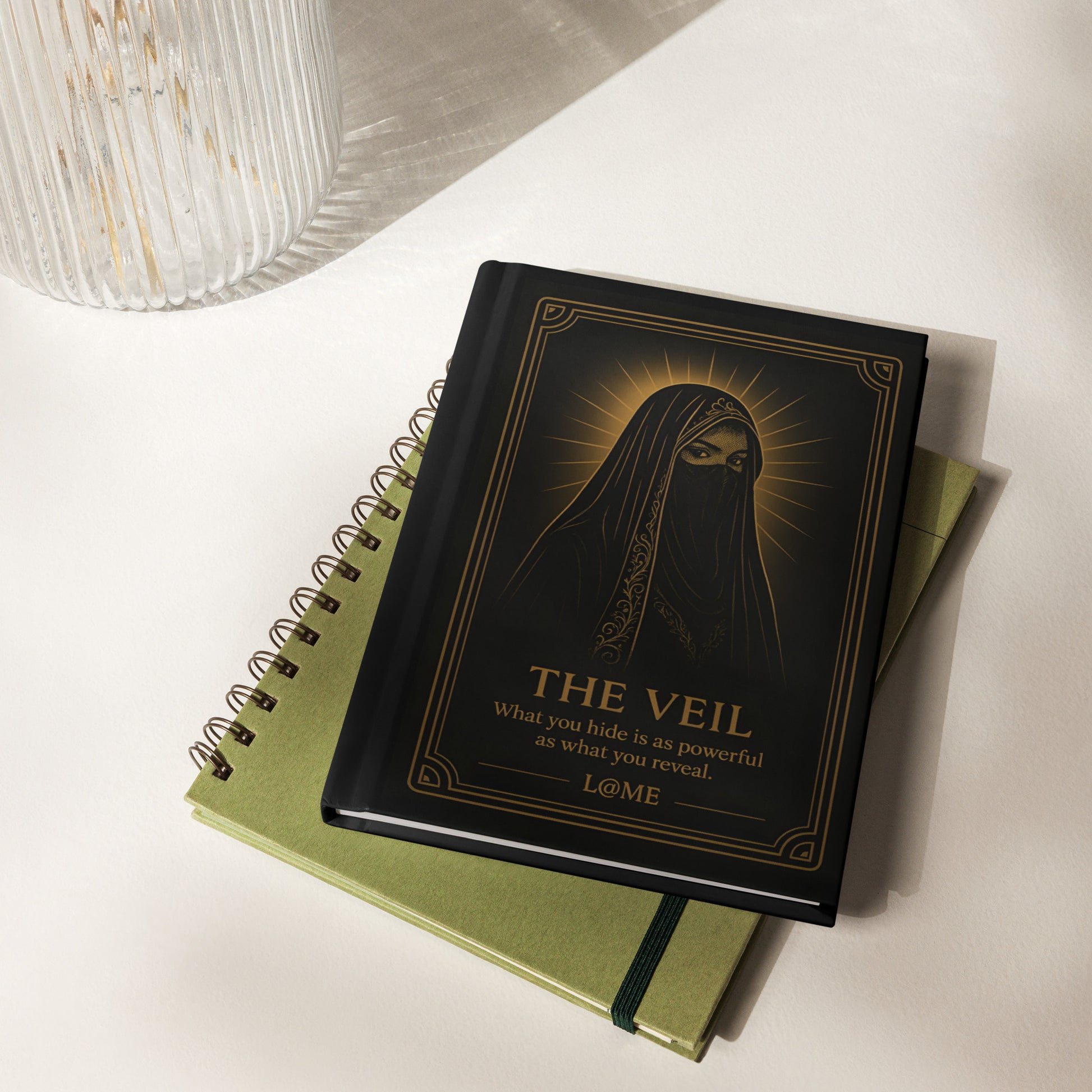 Matte black hardcover journal with gold Veil tarot artwork and lined perforated pages.