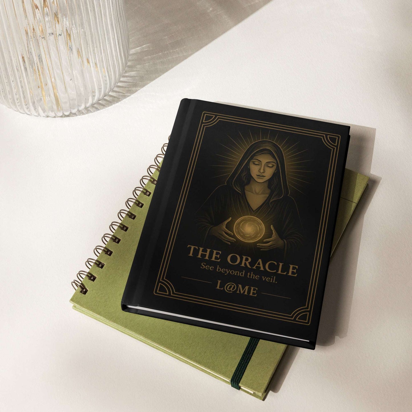 Matte black hardcover journal with gold tarot-style Oracle artwork and lined pages.
